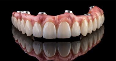Implant dentures for upper arch sitting on reflective surface 