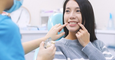 Woman pointing at tooth during a dental implant consultation 