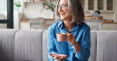 a person smiling and drinking coffee