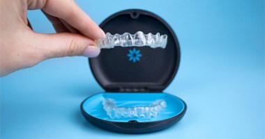 a hand holding Invisalign aligners 