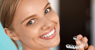 Smiling woman with a clear aligner