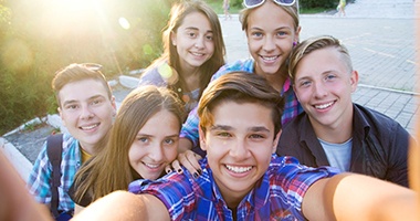 Group of smiling teenagers using Invisalign in Medford