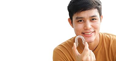 Teenager holding an Invisalign tray