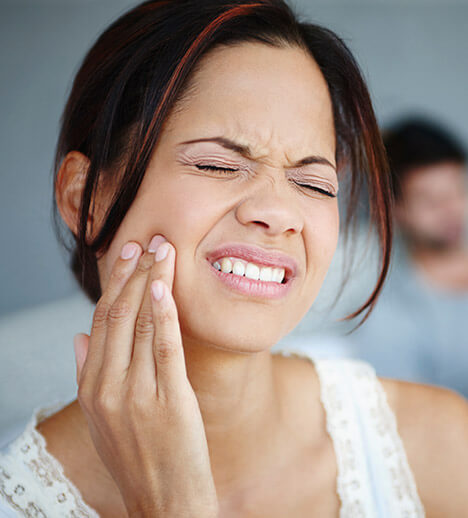 Woman holding mouth in pain