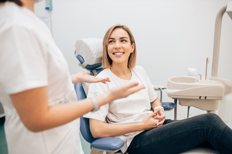 Patient smiling in dentist's chair while discussing sedation dentistry